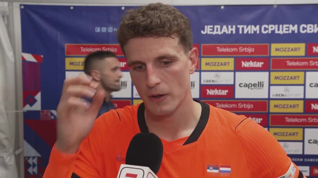 Guus Til in Oranje-tenue tijdens een interview